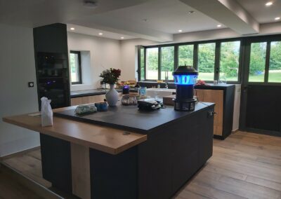 Cuisine avec portes en mélaminé décor bois structuré, dessus en céramique et caissons laqués noirs