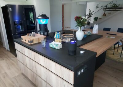 Cuisine avec portes en mélaminé décor bois structuré, dessus en céramique et caissons laqués noirs